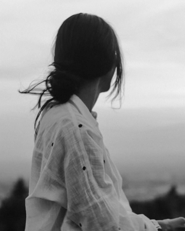 Mujer sentada en su nuevo rincón con gesto de alivio y pertenencia